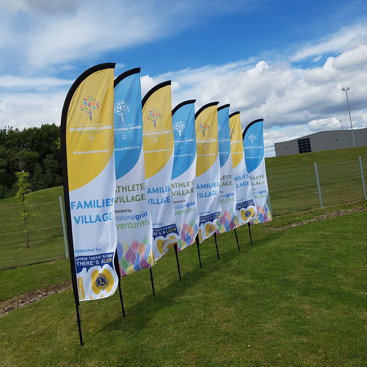 Blue and yellow custom printed flags displayed at an outdoor event