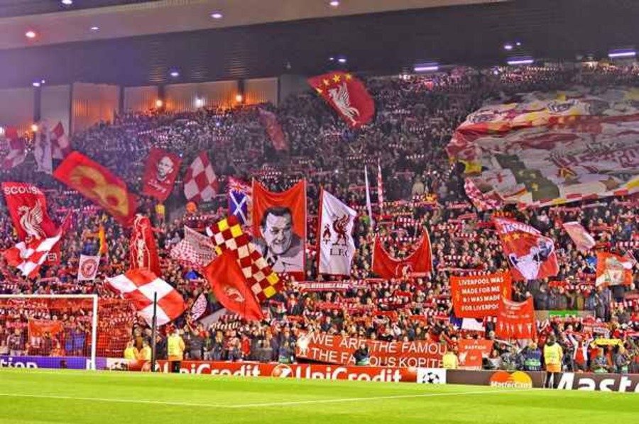 Liverpool fans displaying flags at the Kop End in Anfield Stadium