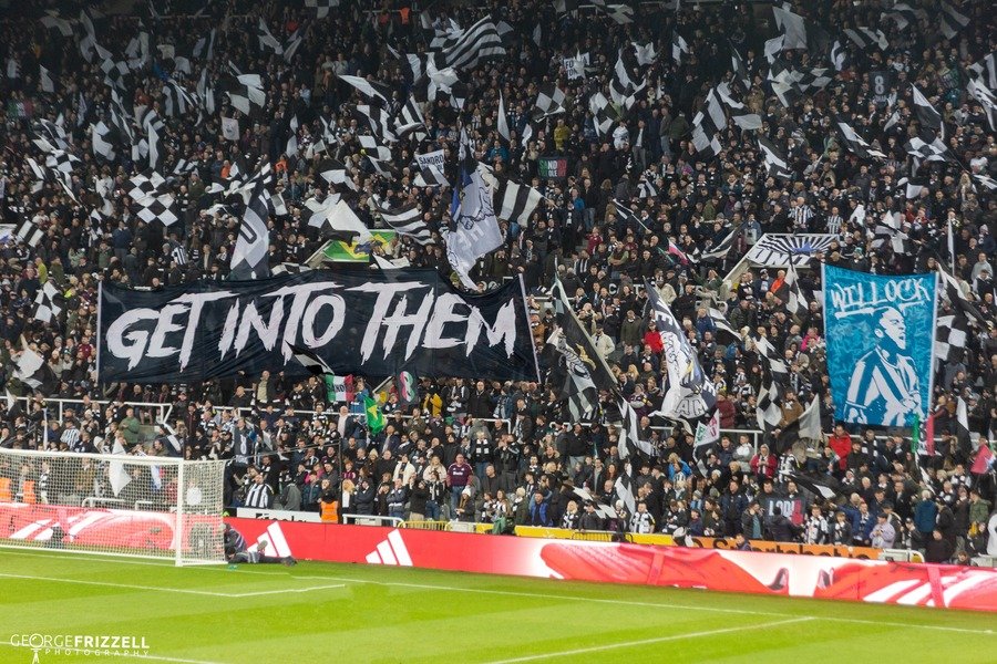 Fans waving black and white flags at St James Park home of Newcastle United